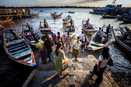 People wait to get on a boat to cross the Yangon river in the centre of Yangon. There are many small boats making the crossing every day. Yangon, daily life, river, crossing, taxi, Myanmar, Asia, travel, photography, Simon Bond.
