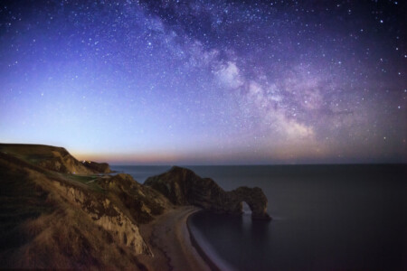 The epic outdoors as the milky way rises over the Jurassic coast in Dorset, the UK. The location of this photo is Durdle Door. Sky, Night, Galaxy, Milky way, Landscape, astrophotography, Jurassic coast, Travel, Simon Bond.