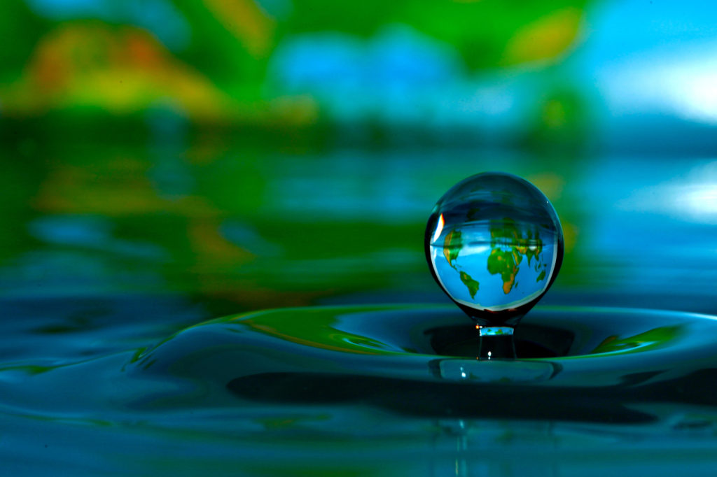 Using pictures in the background can lend a story to your water drop photo.