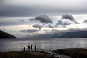 A family admire the view of the might lake Toba. Each silhouette is well defined.