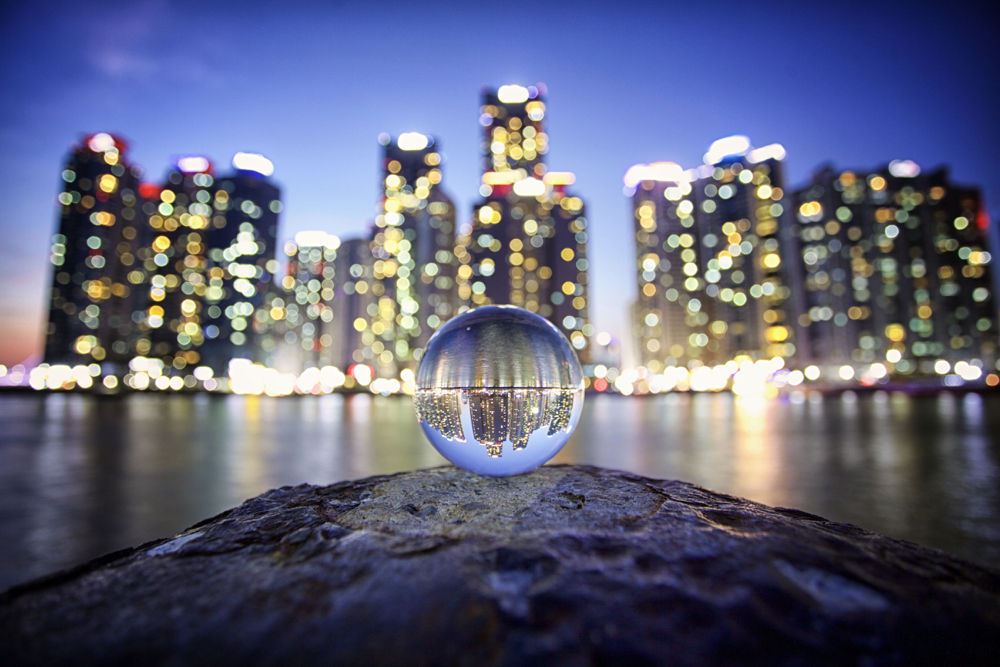 Lensballs are a photography producted used to create a refracted image. In this image a lensball refracts the image of Busan's marine city.
