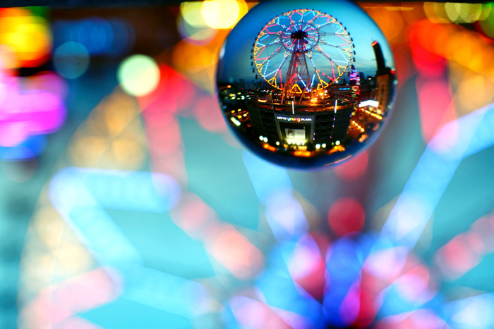The bokeh background is a big part of lensball photography. Here a ferris wheel provides lines of light thoughout the photo, a ferris wheel like this makes an excellent main subject.